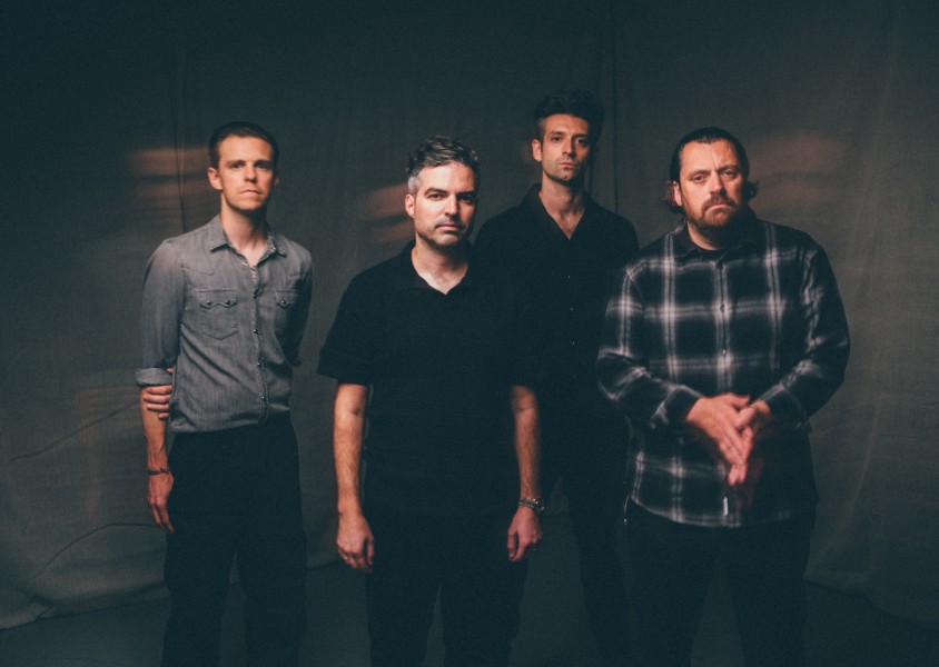 4 men (the boxer rebellion) standing in front of a dark sheet x